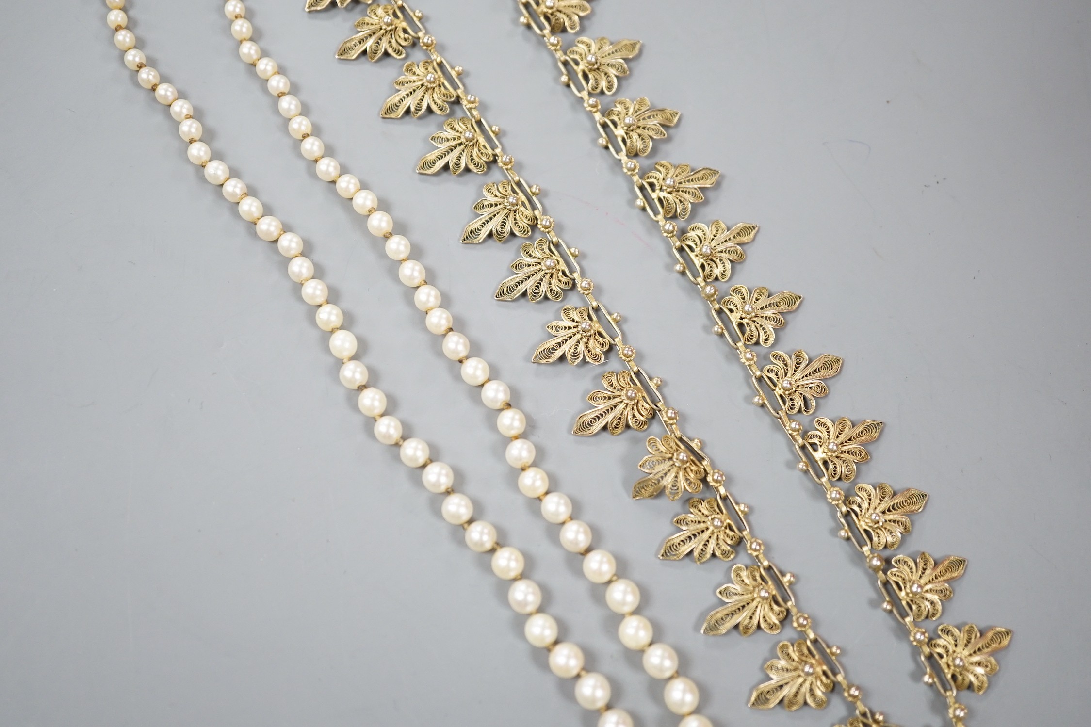 A single strand graduated cultured pearl necklace, with 925 clasp, 21cm and a gilt white metal filigree necklace.